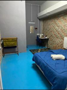a bedroom with a bed and a brick wall at Naja Hotel in Kampung Rahmat