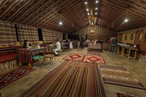 a large room with many carpets on the floor at Wadi Rum Trip Bedouin Camp in Wadi Rum