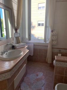 a bathroom with a sink and a toilet and a window at Villa Orsini in Tor Vergata