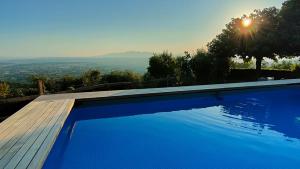 a blue swimming pool with a view of the city at Podere Le Vedute in Larciano