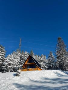 a cabin on a snowy hill with snow covered trees at Vikendica Šumski mir Romanija-Sokolac-Sarajevo-Jahorina in Sokolac