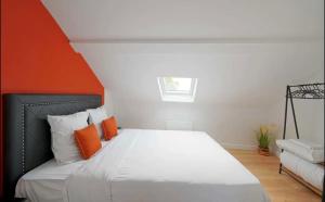 1 dormitorio con 1 cama con almohadas de color naranja y blanco en Suite Savanah, en Lyon