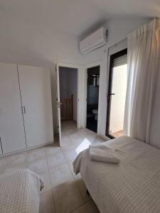 um quarto branco com 2 camas e uma varanda em Casa Alanis em Gran Alacant