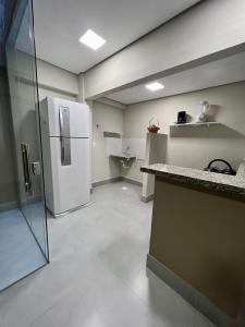une cuisine vide avec un réfrigérateur et un comptoir dans l'établissement Zaffir Apartamento, à Cuiabá