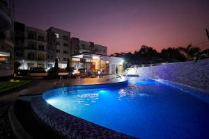 una piscina por la noche con luces azules en Perfect Luxury @ Henrietta’s Residence, en Accra