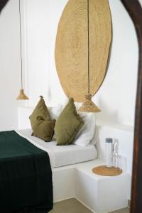een slaapkamer met een bed met kussens en een spiegel bij Casa DantesVoyage - SPA in Nungwi