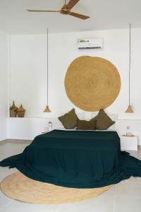 een slaapkamer met een groen bed en een ventilator bij Casa DantesVoyage - SPA in Nungwi