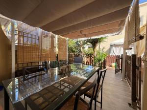 a patio with a glass table and chairs at Canarian Green Oasis by luca properties gran canaria in Maspalomas