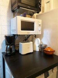 een aanrecht met een magnetron en een koffiezetapparaat bij Valencia Well Located Shared Apartment in Valencia