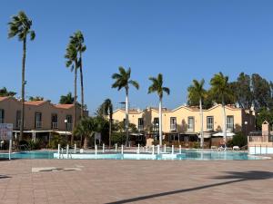 a resort with palm trees and houses in the background at Canarian Green Oasis by luca properties gran canaria in Maspalomas