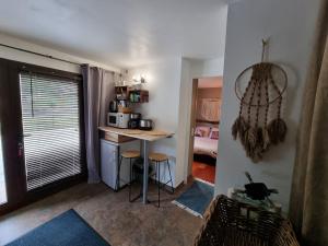 una pequeña cocina con mesa en una habitación en Petite chambre cosy avec salle de bain privative en Saint-Pierre-dels-Forcats