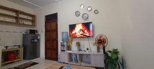 a living room with a tv on a wall at Luca Homes Studio Apartment In Bamburi Mombasa in Mombasa