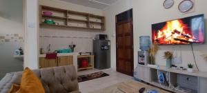 a living room with a couch and a tv on a wall at Luca Homes Studio Apartment In Bamburi Mombasa in Mombasa