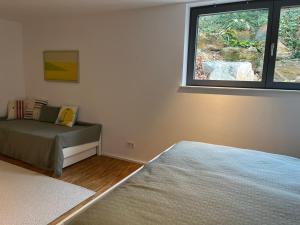 Schlafzimmer mit einem Bett und einem Fenster in der Unterkunft Ruhige Ferienwohnung in Oberhaching bei München in Oberhaching