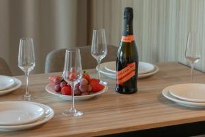 una botella de vino sentada en una mesa con copas de vino en Wyspa Uznam Promenada apartament na Wydmie, en Świnoujście