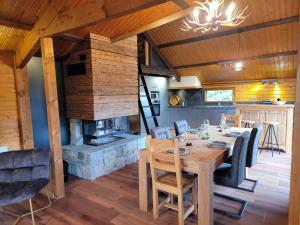a dining room with a table and a fireplace at Chalet Pura Vida - En pleine nature, tout confort in Le Valtin