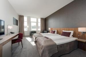 サンドネスにあるQuality Hotel Residenceのベッド2台とデスクが備わるホテルルームです。