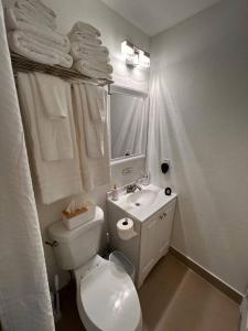 uma casa de banho branca com um WC e um lavatório em Casita Cafe em Miami