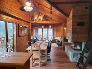 a dining room with a table and a fireplace at Chalet Pura Vida - En pleine nature, tout confort in Le Valtin