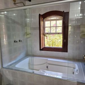 a bath tub in a bathroom with a window at Pousada Serra da Bocaina Paraty in Paraty