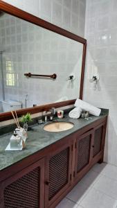 a bathroom with a sink and a large mirror at Pousada Serra da Bocaina Paraty in Paraty