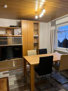 a room with a table and chairs and a television at Ferienwohnung am Moor in Rehden