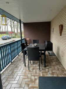a patio with a table and chairs on a balcony at Ferienwohnung am Moor in Rehden