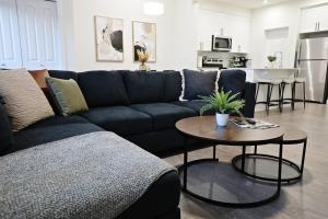un soggiorno con divano blu e tavolo di Escape in Style, Golf,King Beds,Disney+,Near WEM a Edmonton