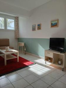 卡瓦拉的住宿－Green Garden，客厅配有平面电视和桌子。