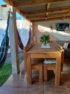 un tavolo e sedie in legno su una veranda con amaca di Recanto Figueira Silvestre a Cidreira