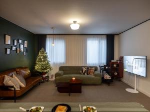 a living room with a couch and a christmas tree at Namsan Tower 5min in Seoul
