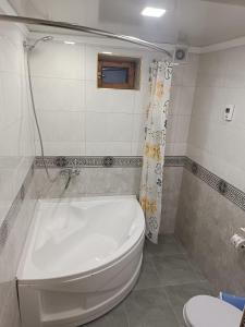 y baño con aseo blanco y bañera. en Khiva Ibrohim Guest House, en Khiva
