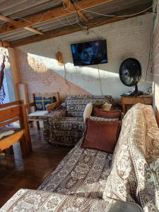 a living room with a couch and a tv at Recanto Figueira Silvestre in Cidreira