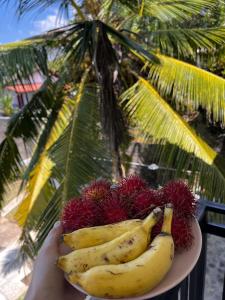 a person holding a plate of bananas and other fruit at WILSON VILLA in Hikkaduwa