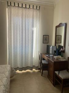 - une chambre avec un bureau, un ordinateur et une fenêtre dans l'établissement Villa Orsini, à Tor Vergata