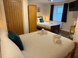 a hotel room with two beds and a window at The Beresford Arms in Morpeth