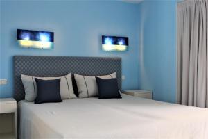 a bedroom with a large bed with blue walls at Residence Les Oliviers in Porto Azzurro