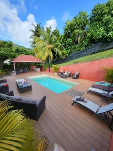 a backyard with a swimming pool and a wooden deck at Résidence Belle Anse Trois-ilets in Les Trois-Îlets