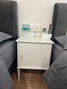 タイピンにあるKIWI INNの白いドレッサー(ベッド2台の横にボトル入り飲料水付)