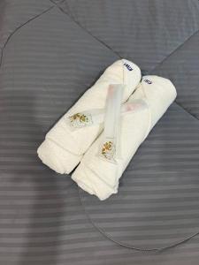 a pair of towels sitting on top of a bed at KIWI INN in Taiping
