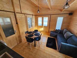 ein Wohnzimmer mit einem blauen Sofa und einem Tisch in der Unterkunft Domki Letniskowe przy Strażnicy in Radków