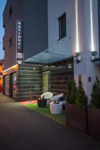 a building with chairs and plants in front of it at Hotel National in Zagreb
