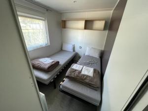 a small room with two beds and a window at Grand Mobil Home in Houlgate