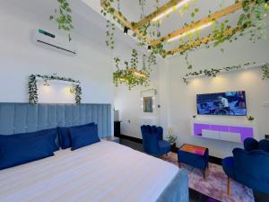 a bedroom with a large bed and blue chairs at Holiday Homes Guest Inn - Ella in Ella