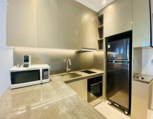 una cucina con forno a microonde e lavandino di The Rixx Simple Apartment @ Marq/pool/gym/Netflix ad Ho Chi Minh