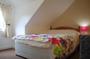 a bedroom with a bed with a colorful blanket on it at Clift Guest House in Bristol