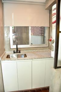 a kitchen counter with a sink and a window at DEPARTAMENTO PEATONAL SARMIENTO PLENO CENTRO MENDOZA 3-4 Personas, Con Cochera GRATIS ! in Mendoza