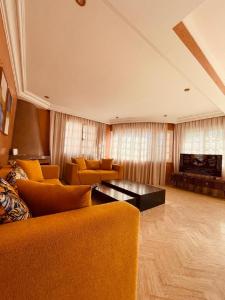 uma sala de estar com cadeiras laranja e uma mesa em Villa Dune Rouge de la Siesta em Mohammedia