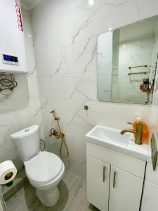 een witte badkamer met een toilet en een wastafel bij Brand new apartment Chisinau not far from the airport in Chişinău