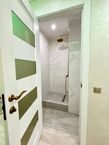 een badkamer met een inloopdouche naast een glazen deur bij Brand new apartment Chisinau not far from the airport in Chişinău